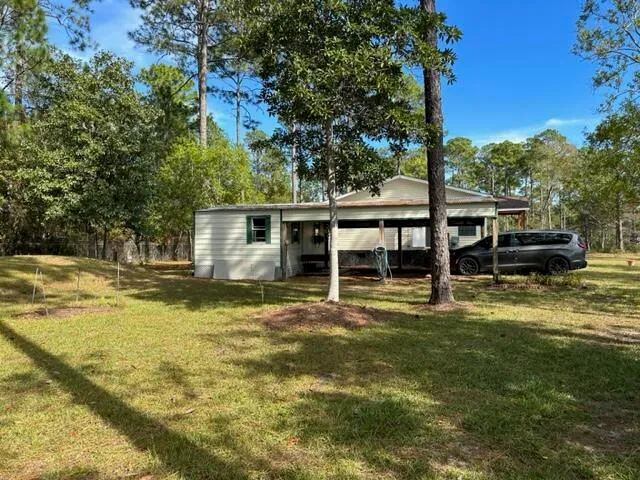 a view of a house with a yard patio and swimming pool