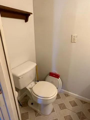 a white toilet sitting next to a white sink and vanity