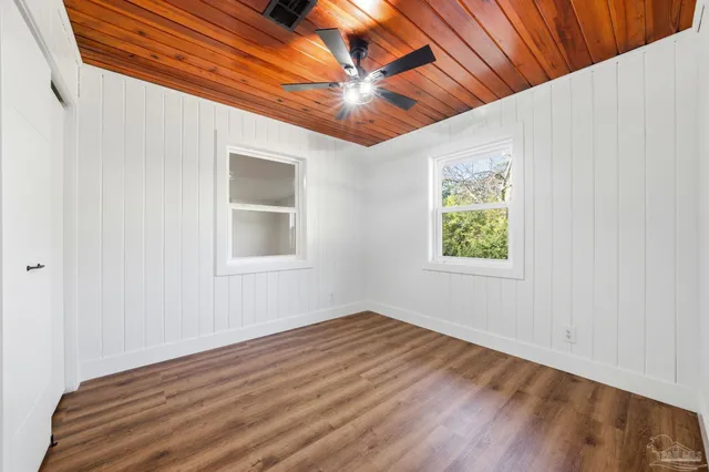 a view of empty room with wooden floor