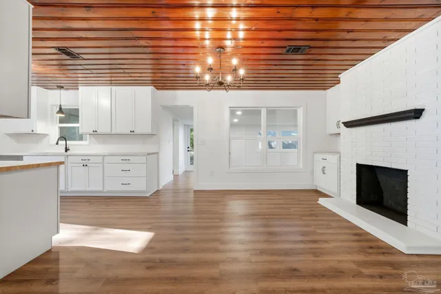 a view of a kitchen with wooden floor and a fireplace