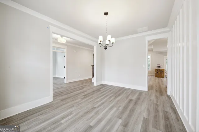 a view of a hallway with wooden floor and windows