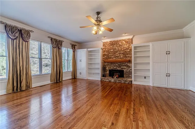 a view of an empty room with chandelier fan