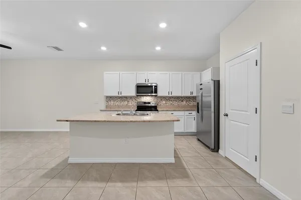 a kitchen with granite countertop a sink a stove and microwave