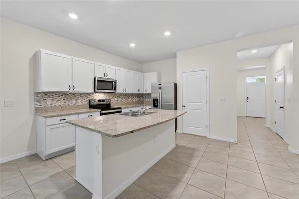 a kitchen with stainless steel appliances granite countertop a refrigerator and a sink