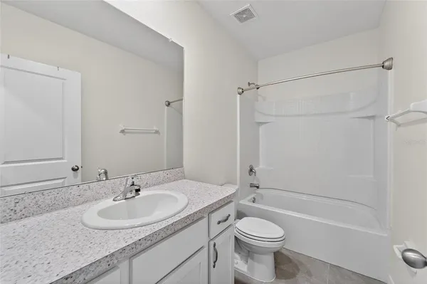 a view of a storage & utility room with refrigerator and window
