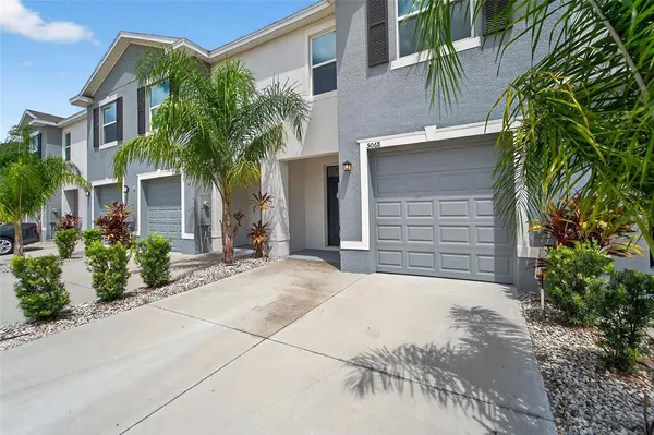 a front view of a house with a yard and potted plants