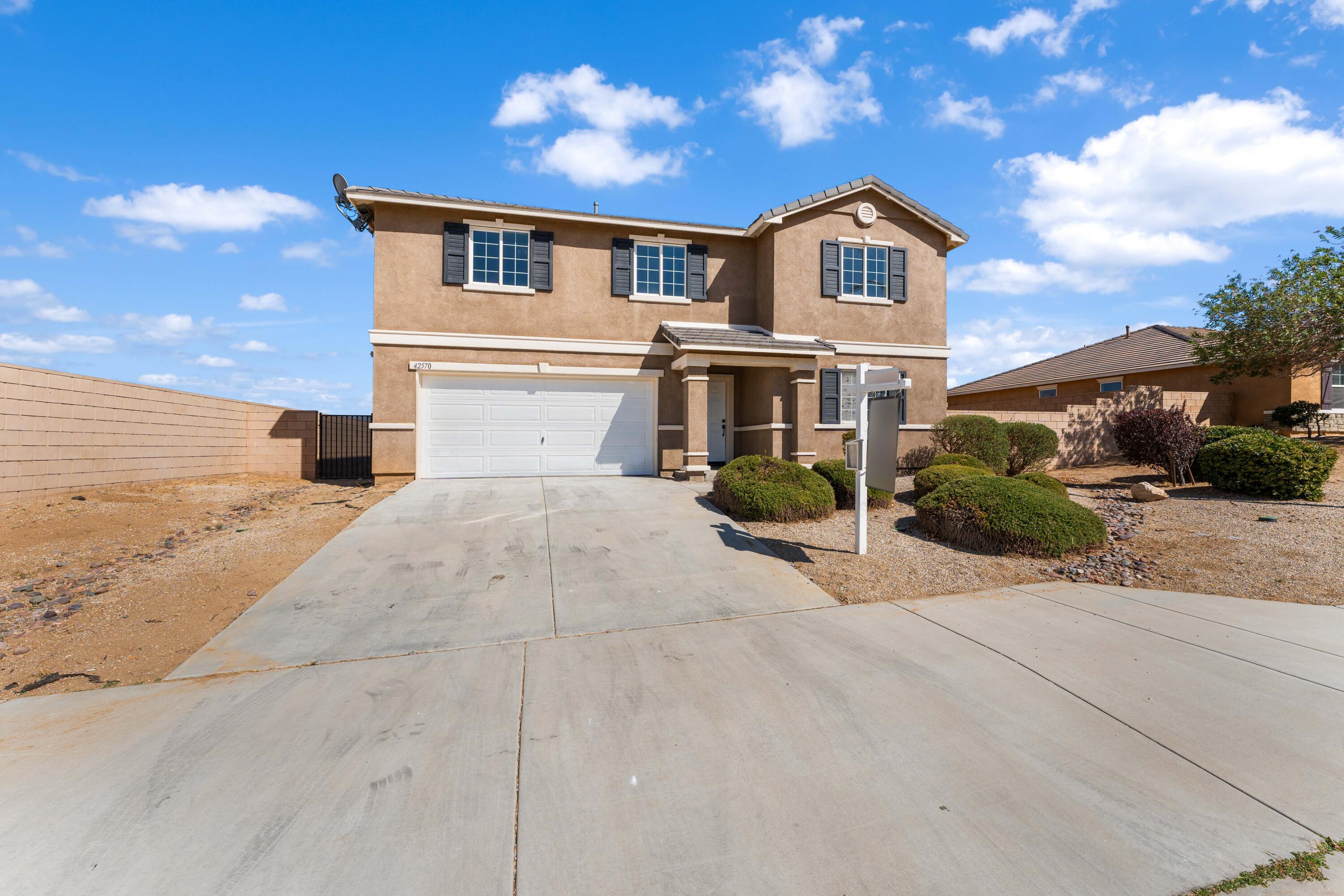 42570 72nd Street West Lancaster, CA 93536 - Photo 15 of 43 a front view of a house with a yard and garage