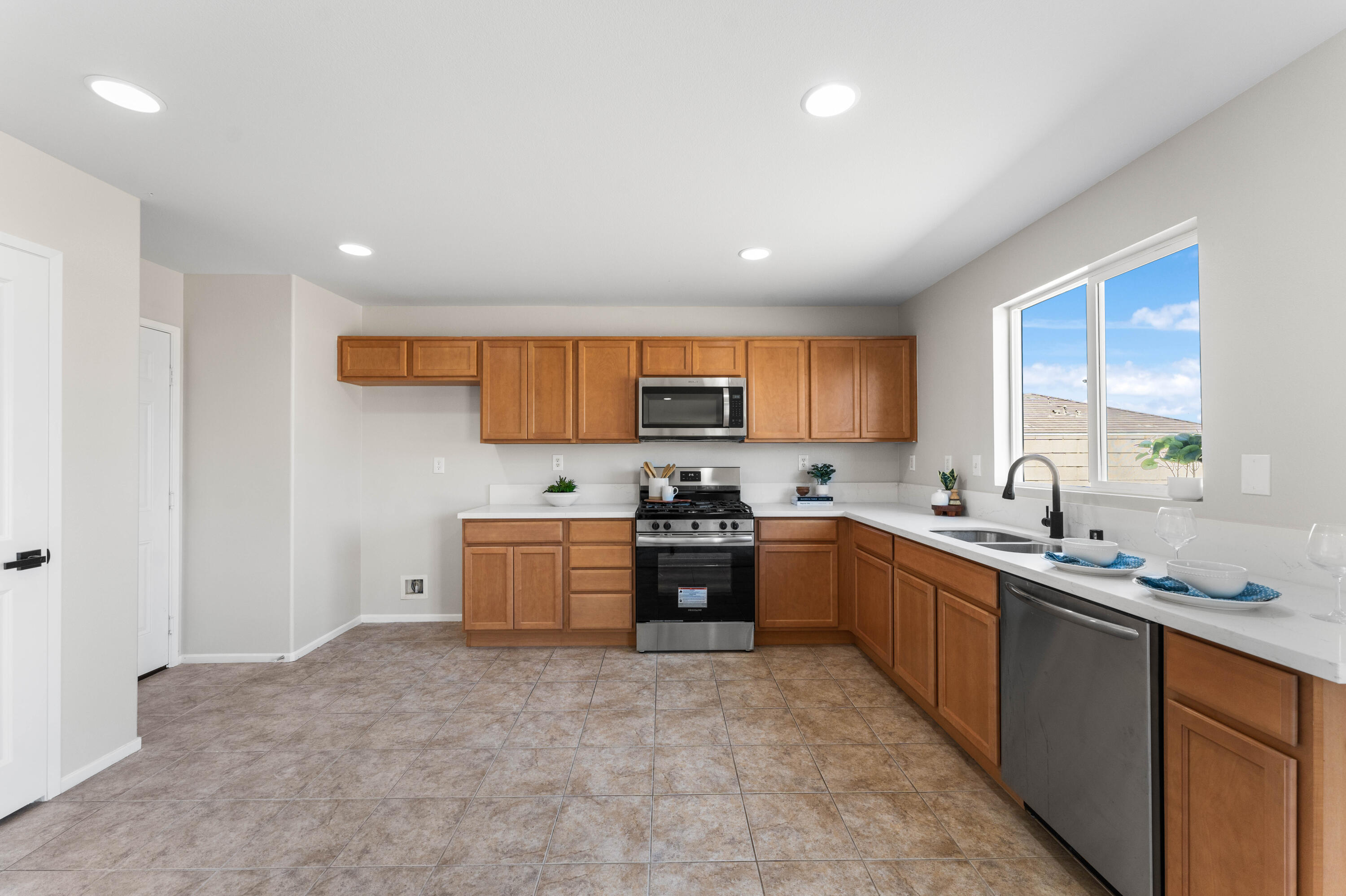 42570 72nd Street West Lancaster, CA 93536 - Photo 17 of 43 a large kitchen with stainless steel appliances granite countertop a stove a sink dishwasher and a refrigerator