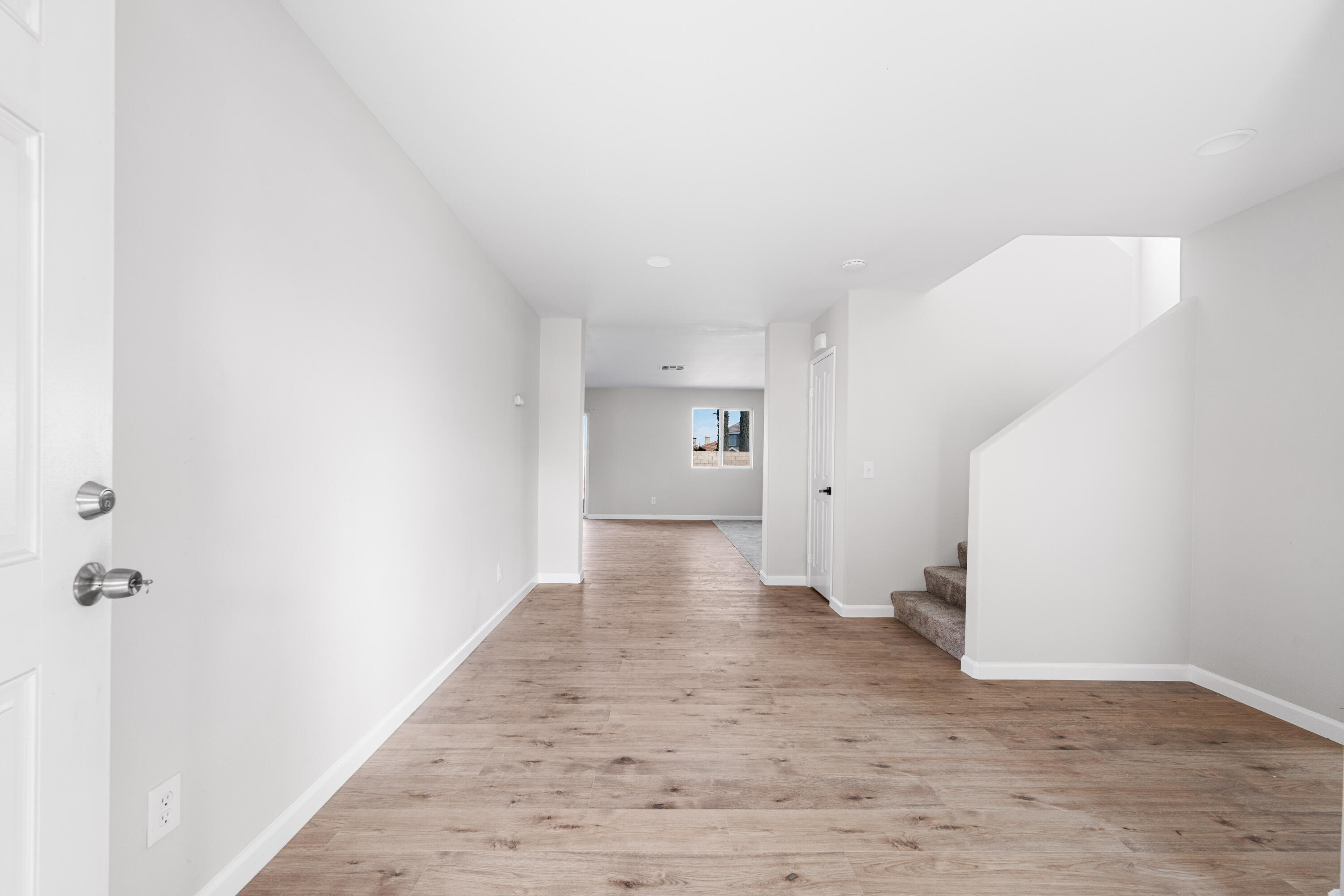 42570 72nd Street West Lancaster, CA 93536 - Photo 2 of 43 a view of a hallway with wooden floor and a bathroom