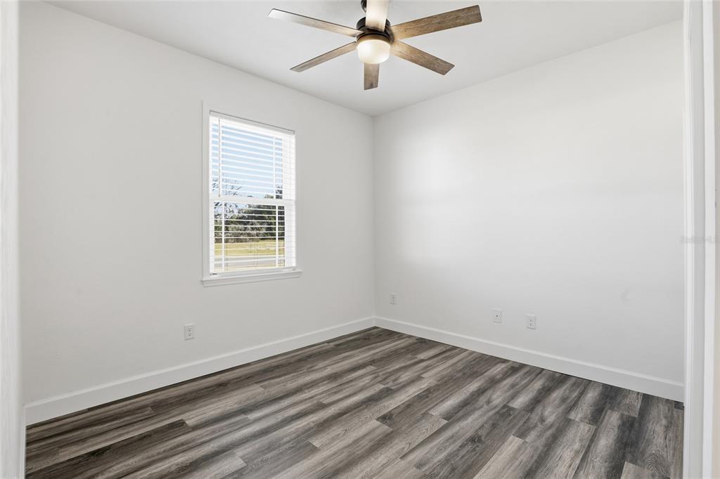 24302 Southwest 18th Road Newberry, FL 32669 - Photo 16 of 30 an empty room with a window and ceiling fan