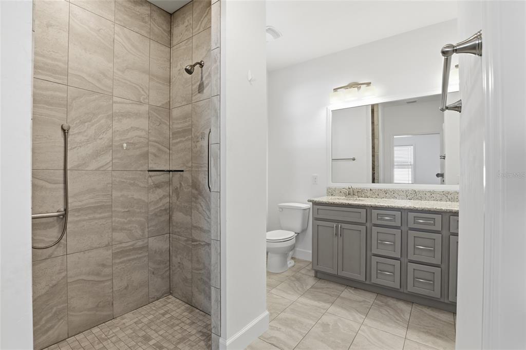 24302 Southwest 18th Road Newberry, FL 32669 - Photo 19 of 30 a bathroom with a granite countertop sink toilet and shower