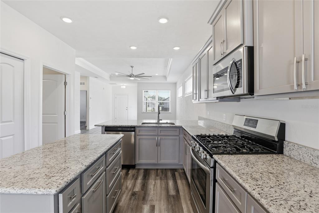 24302 Southwest 18th Road Newberry, FL 32669 - Photo 5 of 30 a kitchen with granite countertop a sink stove and cabinets