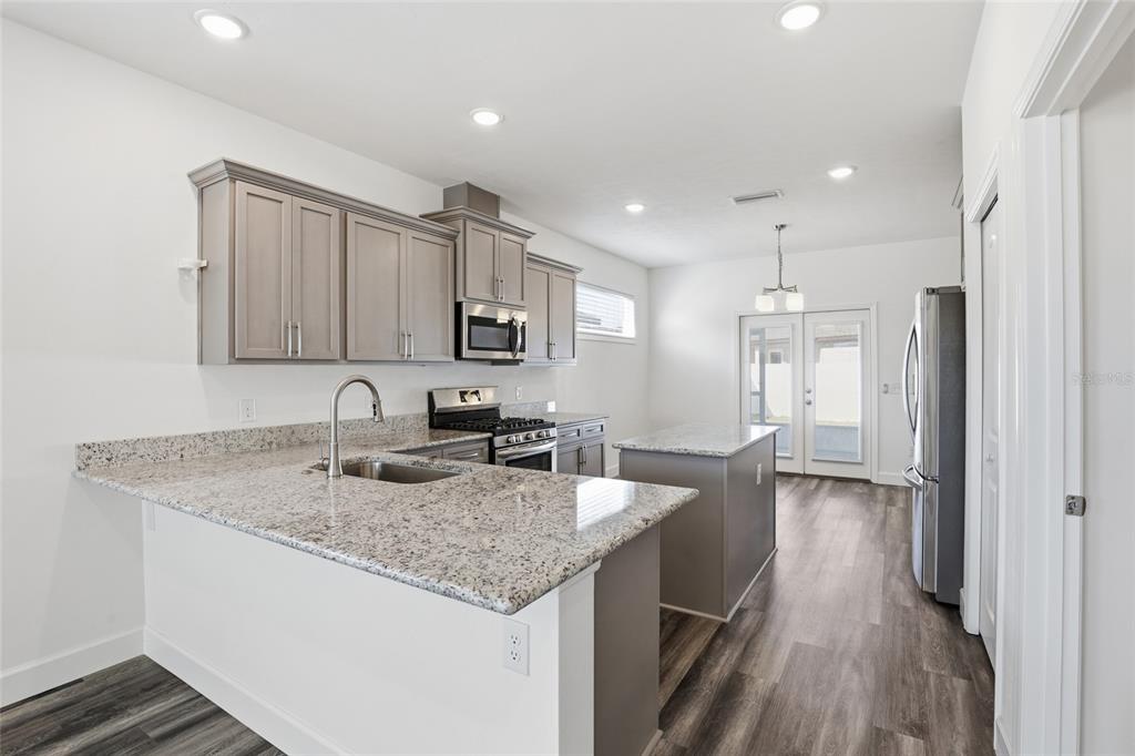 24302 Southwest 18th Road Newberry, FL 32669 - Photo 9 of 30 a kitchen with stainless steel appliances granite countertop a sink refrigerator and cabinets