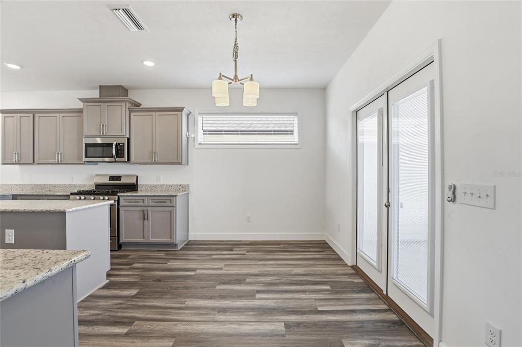 24302 Southwest 18th Road Newberry, FL 32669 - Photo 10 of 30 a kitchen with stainless steel appliances granite countertop a refrigerator and a stove top oven
