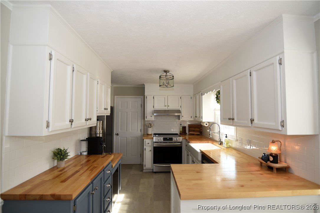 210 Tartan Road Lumberton, NC 28358 - Photo 13 of 38 a kitchen with stainless steel appliances granite countertop a stove top oven a sink a counter space and cabinets