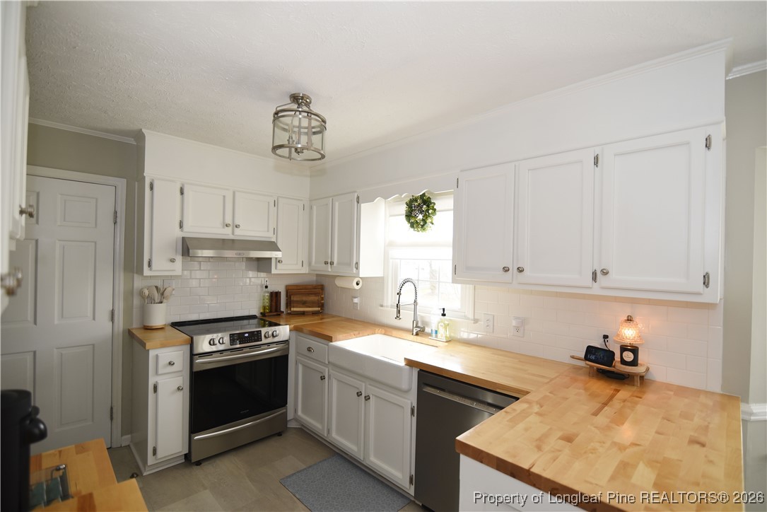 210 Tartan Road Lumberton, NC 28358 - Photo 14 of 38 a kitchen with stainless steel appliances granite countertop a sink stove refrigerator and cabinets