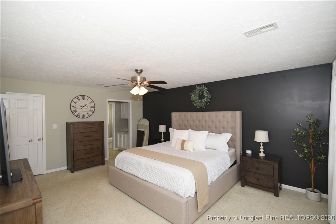 210 Tartan Road Lumberton, NC 28358 - Photo 22 of 38 a bedroom with a bed and a chandelier