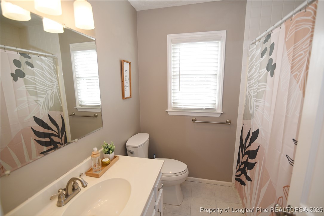 210 Tartan Road Lumberton, NC 28358 - Photo 30 of 38 a bathroom with a sink a toilet and a window