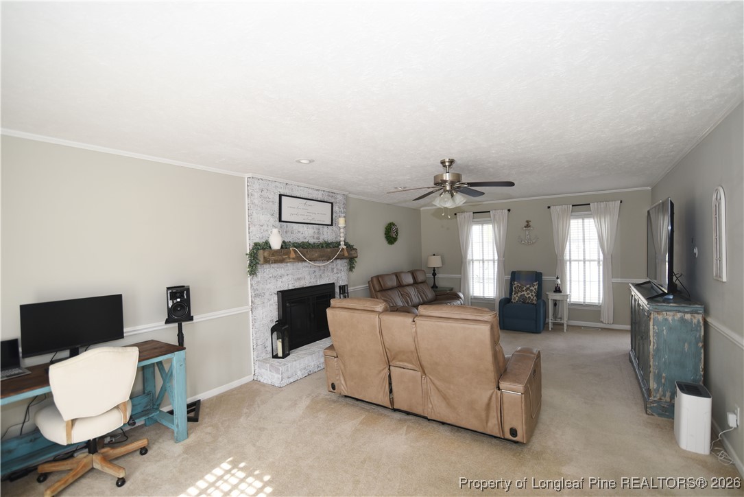 210 Tartan Road Lumberton, NC 28358 - Photo 8 of 38 a living room with furniture a fireplace and a flat screen tv