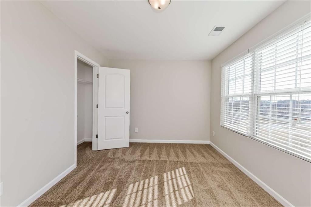 40 Tuesday Court Covington, GA 30016 - Photo 16 of 20 a view of empty room with wooden floor and fan