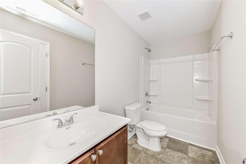 40 Tuesday Court Covington, GA 30016 - Photo 19 of 20 a bathroom with a sink a toilet and a bathtub