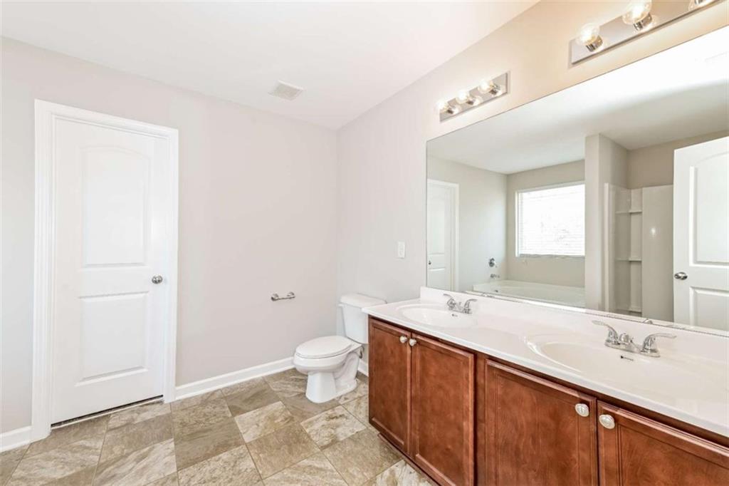 40 Tuesday Court Covington, GA 30016 - Photo 20 of 20 a spacious bathroom with a granite countertop sink and a mirror