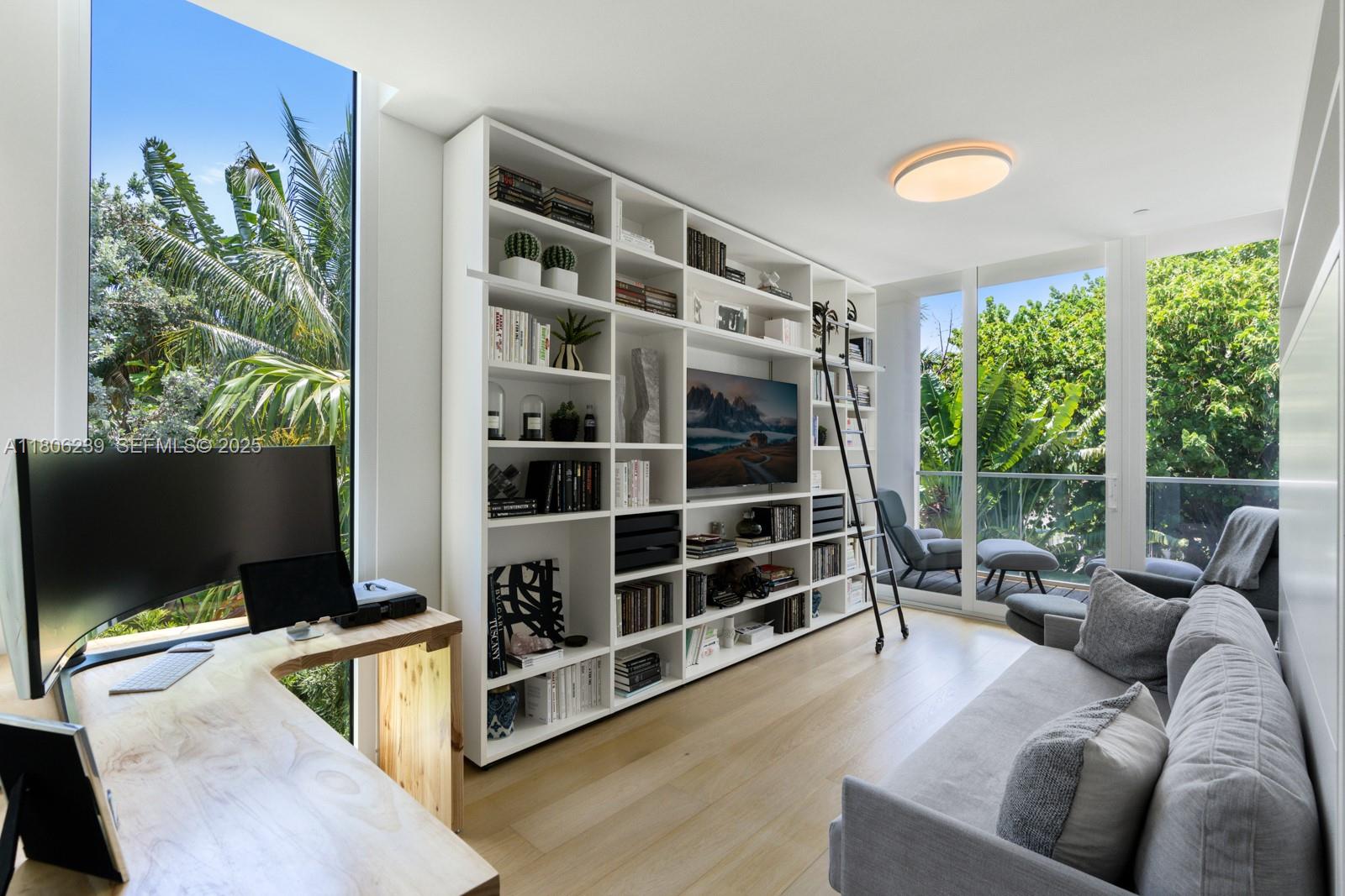 4700 Meridian Avenue Miami Beach, FL 33140 - Photo 44 of 64 a living room with furniture a flat screen tv and floor to ceiling window