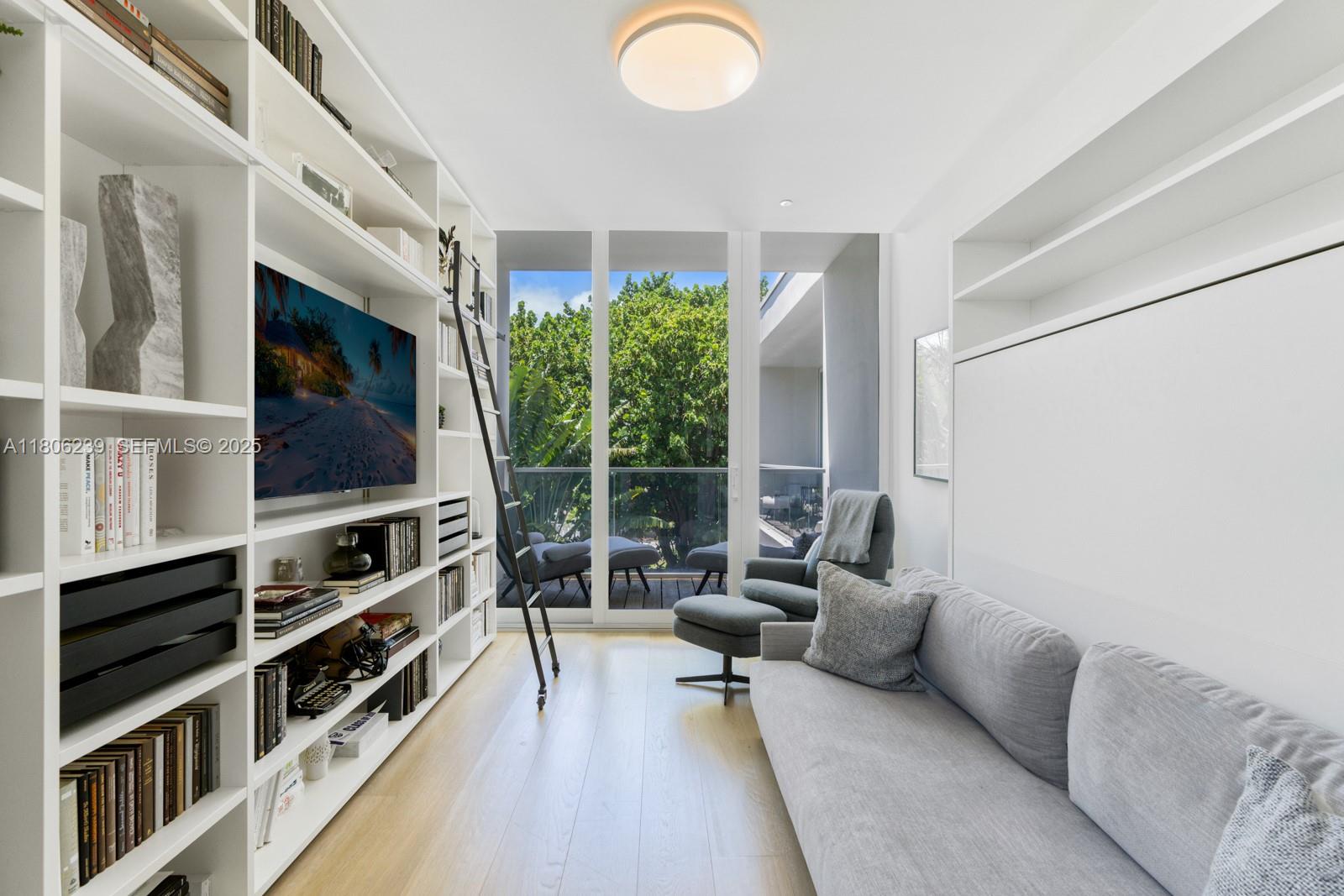 4700 Meridian Avenue Miami Beach, FL 33140 - Photo 45 of 64 a living room with furniture a flat screen tv and a floor to ceiling window