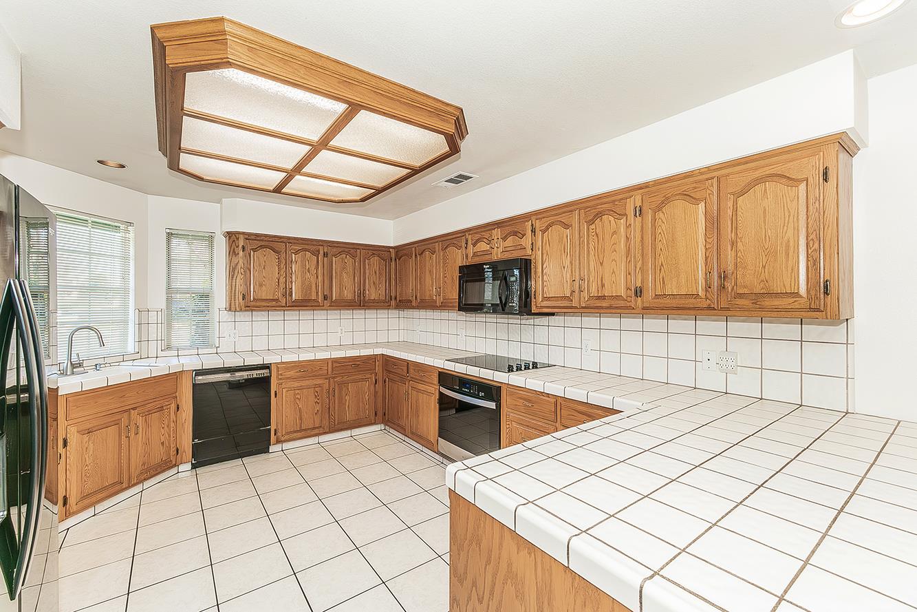1415 West Riverglen Avenue Reedley, CA 93654 - Photo 11 of 48 a kitchen with stainless steel appliances a sink a stove top oven a counter space and cabinets