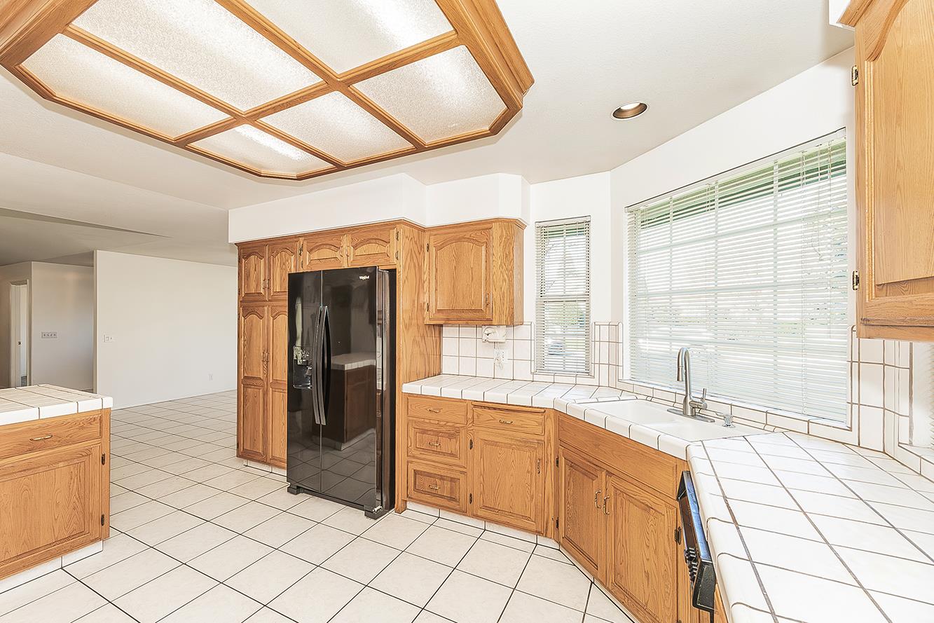 1415 West Riverglen Avenue Reedley, CA 93654 - Photo 12 of 48 a kitchen with stainless steel appliances kitchen island granite countertop a refrigerator and a sink