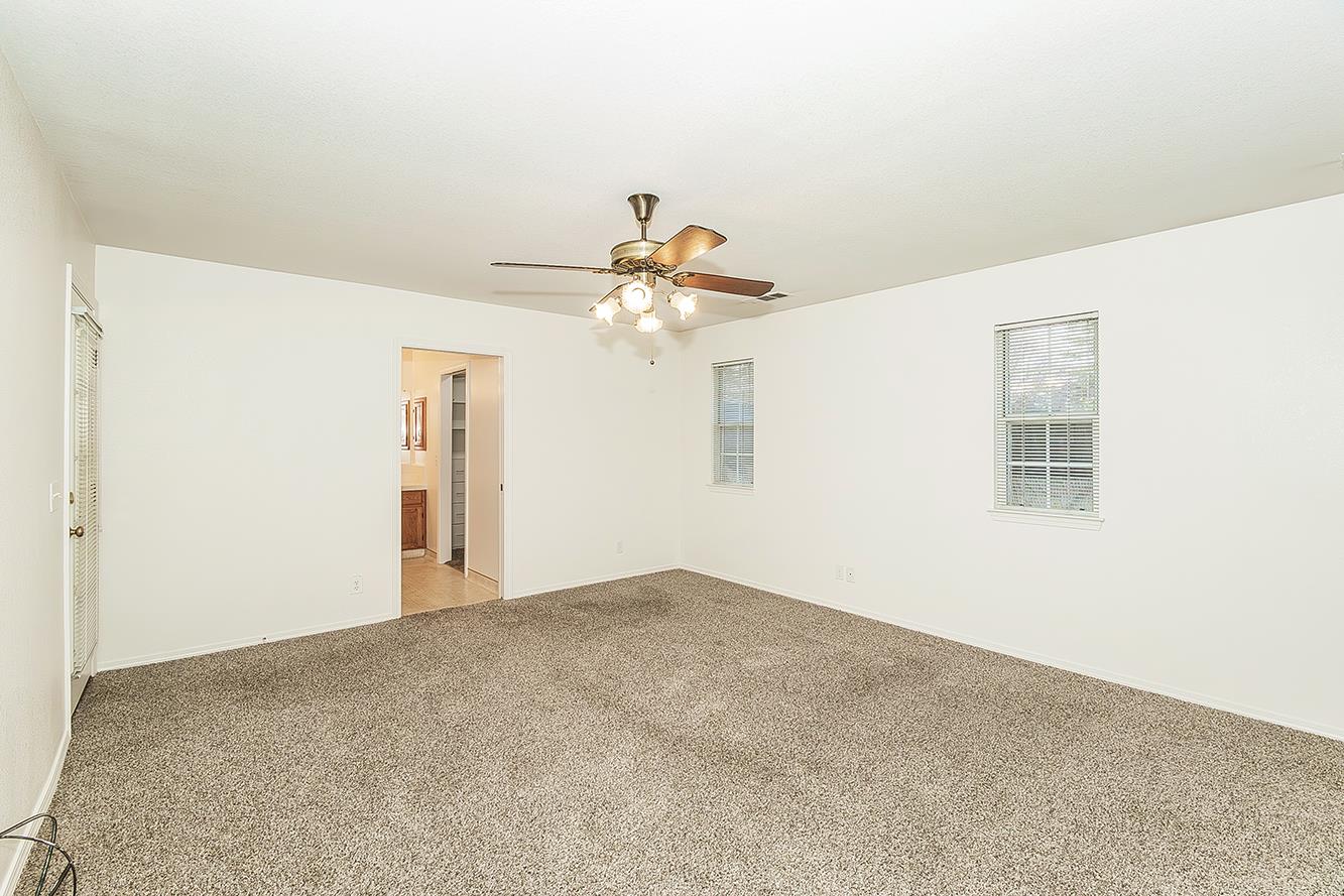 1415 West Riverglen Avenue Reedley, CA 93654 - Photo 14 of 48 a view of a big room with carpet and chandelier fan
