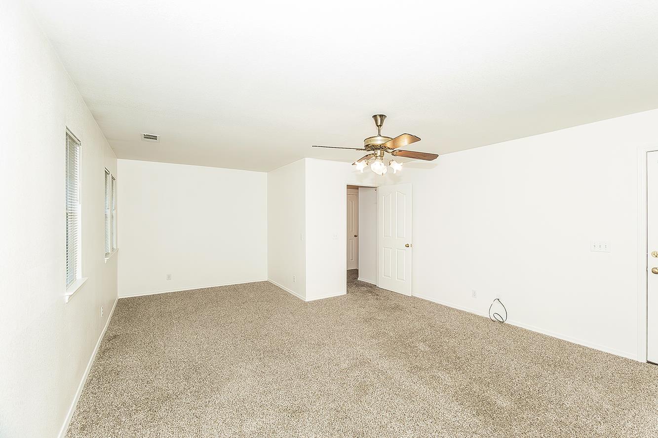 1415 West Riverglen Avenue Reedley, CA 93654 - Photo 15 of 48 an empty room with a chandelier fan and closet