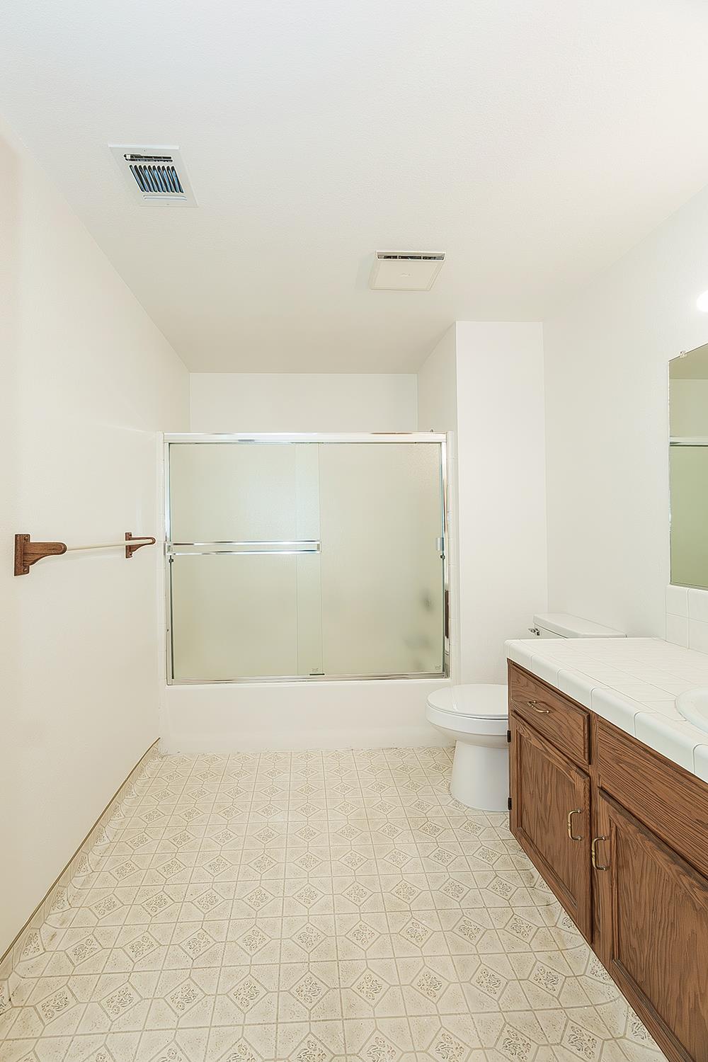 1415 West Riverglen Avenue Reedley, CA 93654 - Photo 25 of 48 a bathroom with a granite countertop sink a toilet and shower