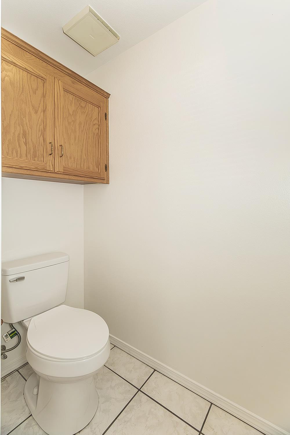 1415 West Riverglen Avenue Reedley, CA 93654 - Photo 29 of 48 a white toilet sitting next to a white cabinet