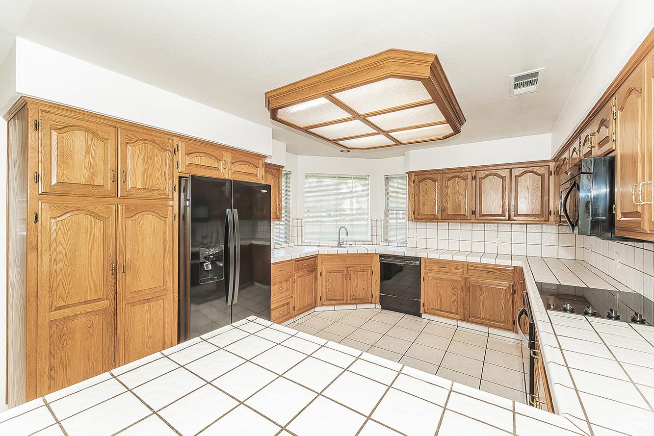 1415 West Riverglen Avenue Reedley, CA 93654 - Photo 10 of 48 a kitchen with stainless steel appliances kitchen island granite countertop a refrigerator and a stove top oven