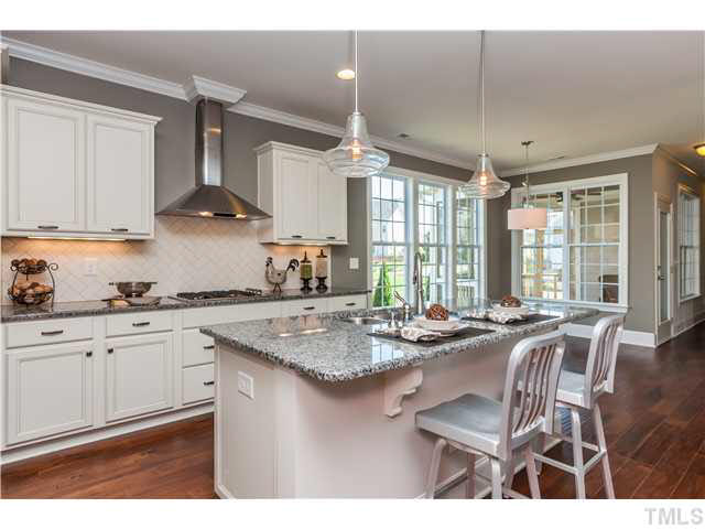 1345 Revolution Circle Raleigh, NC 27603 - Photo 3 of 20 a kitchen with stainless steel appliances granite countertop sink stove and white cabinets