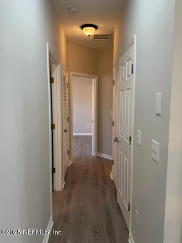 a view of a hallway with wooden floor