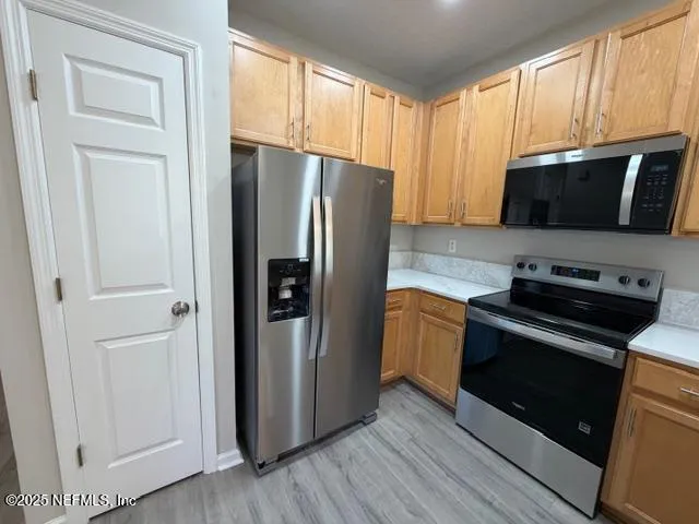a kitchen with granite countertop a refrigerator stove and microwave