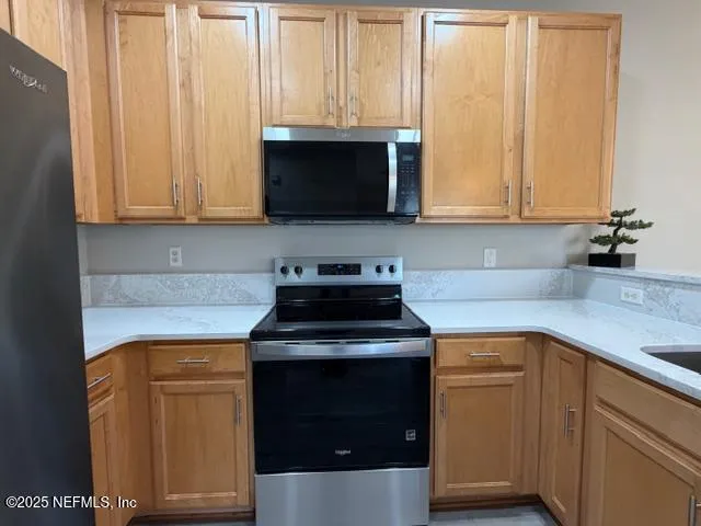 a kitchen with granite countertop white cabinets and black appliances