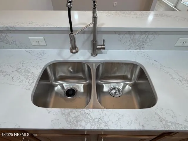 a utility room with sink and mirror
