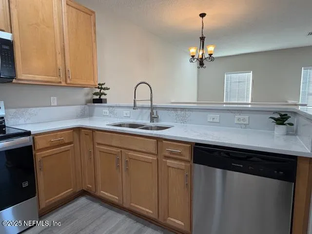 a kitchen with stainless steel appliances granite countertop a sink dishwasher and cabinets with wooden floor