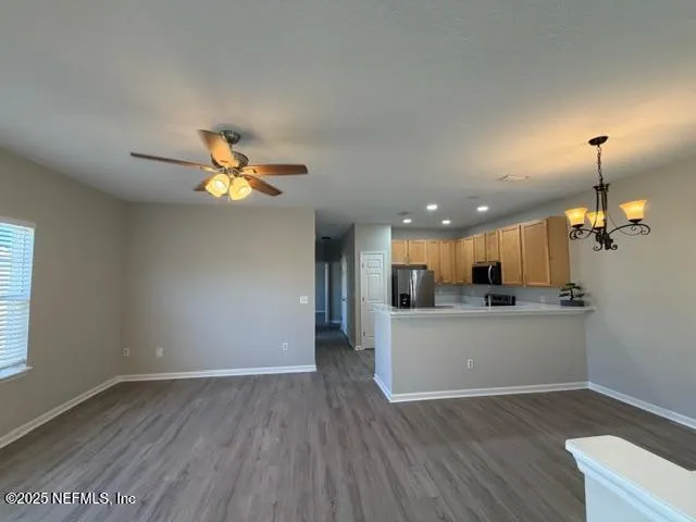 a view of a kitchen with a sink and dishwasher a refrigerator with wooden floor