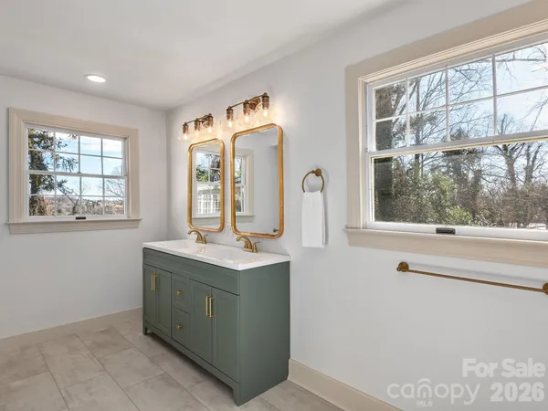 a room with a window a sink and a mirror