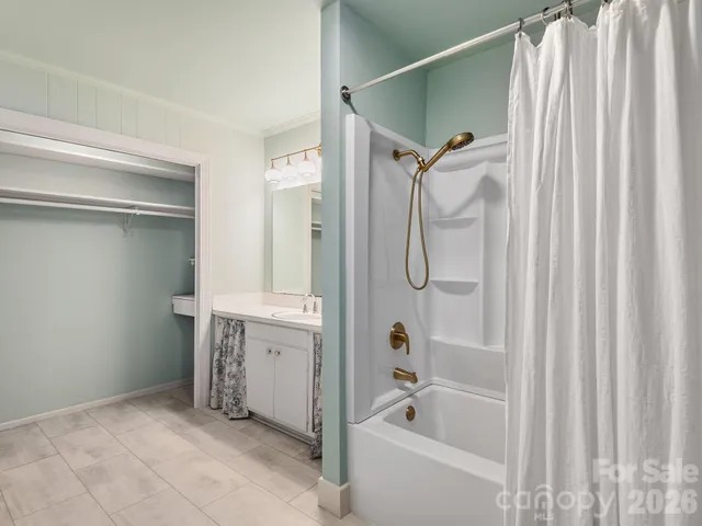 a bathroom with a bathtub shower and a sink
