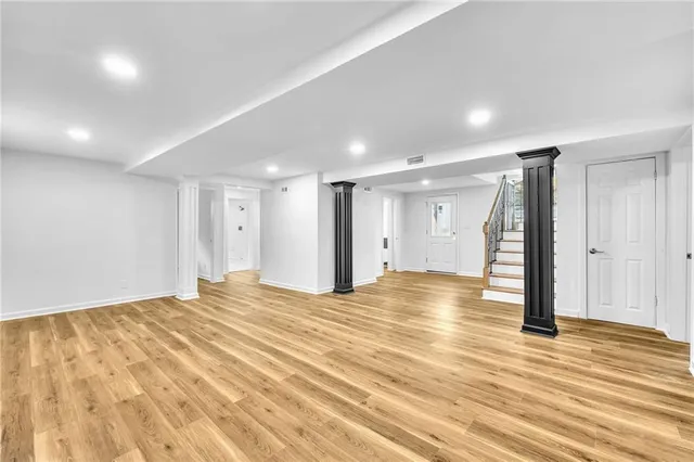 a view of empty room with wooden floor