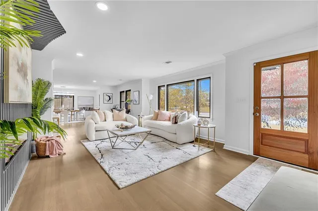 a living room with furniture floor to ceiling window and wooden floor