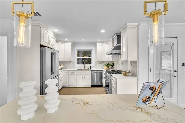 a kitchen with stainless steel appliances kitchen island granite countertop a refrigerator and a sink