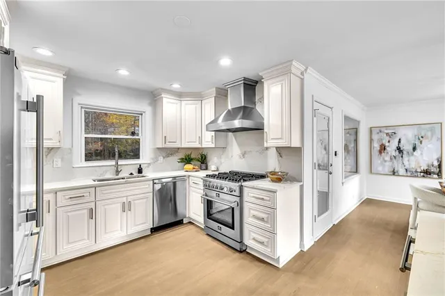 a large kitchen with stainless steel appliances granite countertop a stove and a sink