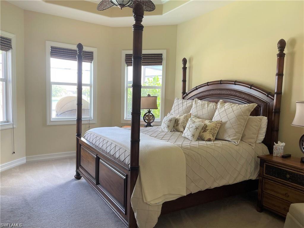 6557 Caldecott Drive Naples, FL 34113 - Photo 6 of 14 a bedroom with a bed and a chandelier