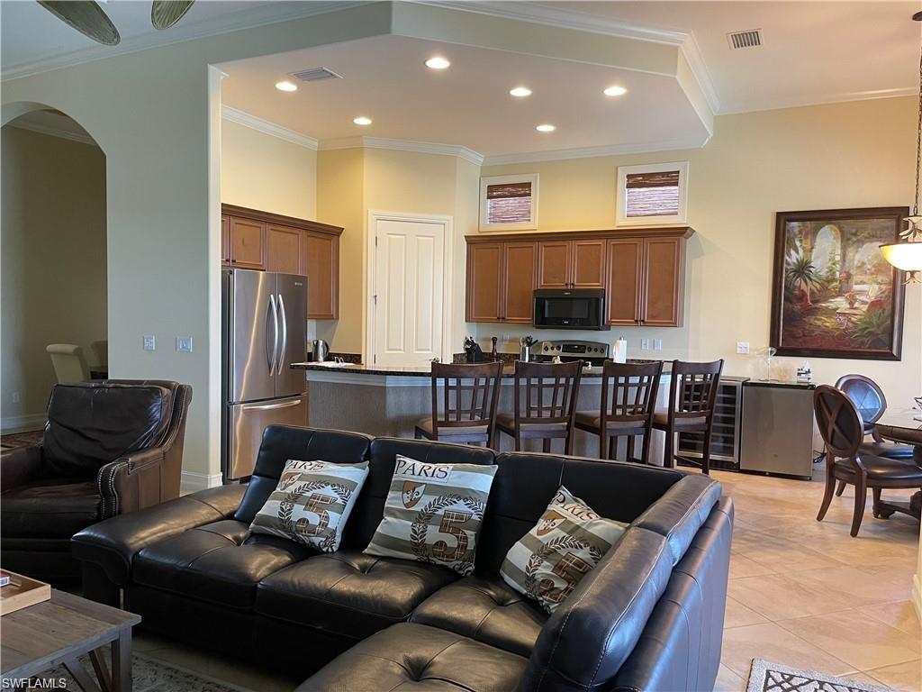 6557 Caldecott Drive Naples, FL 34113 - Photo 8 of 14 a living room with furniture and a flat screen tv
